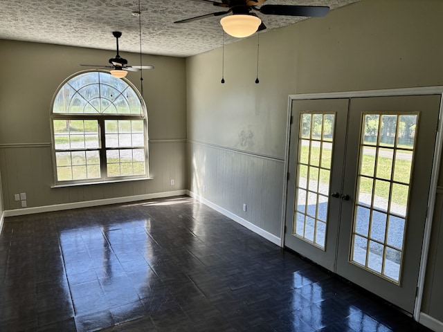 unfurnished room with french doors, a textured ceiling, and a wealth of natural light