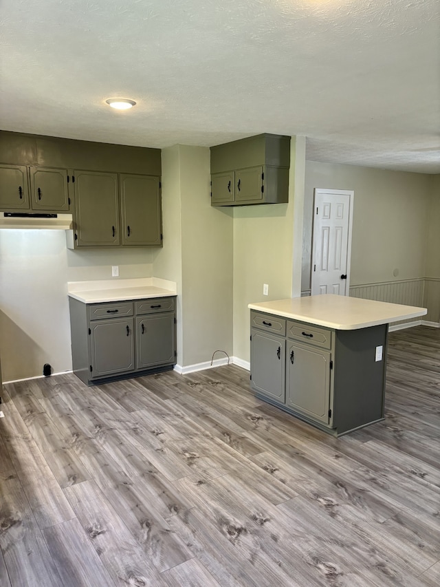 kitchen with a textured ceiling and light hardwood / wood-style flooring