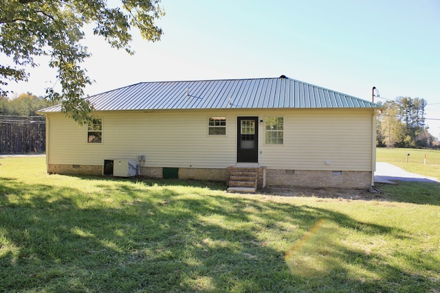 rear view of house with cooling unit and a lawn