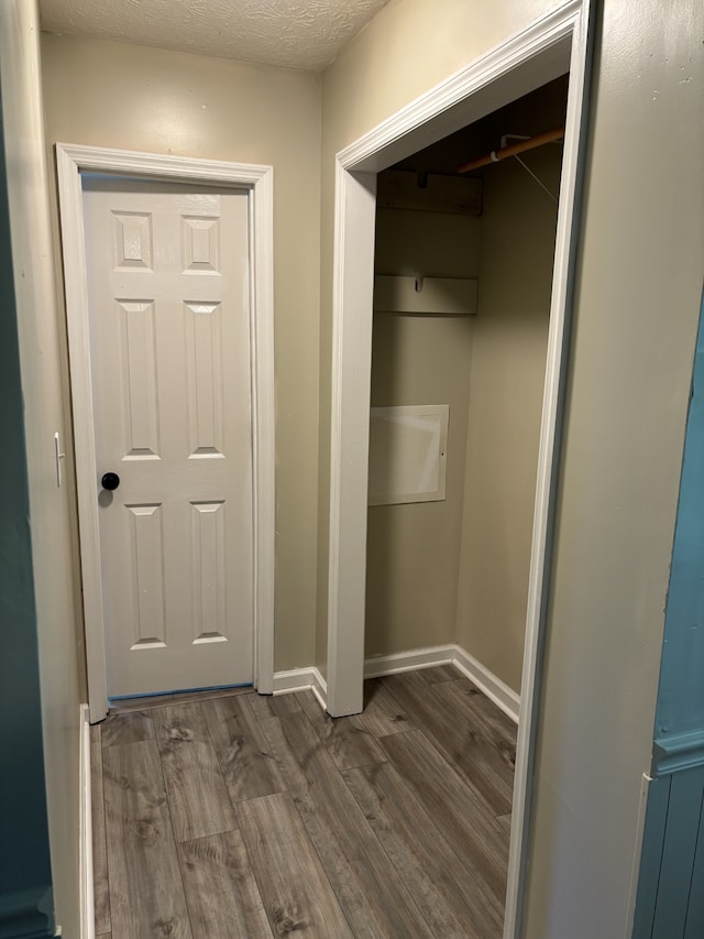 laundry room with a textured ceiling and dark hardwood / wood-style flooring