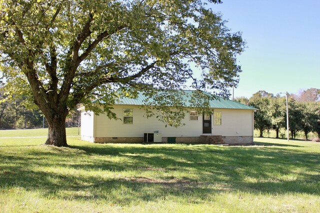 exterior space featuring central AC and a yard