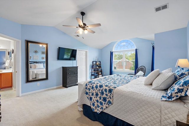 carpeted bedroom featuring ensuite bathroom, vaulted ceiling, and ceiling fan