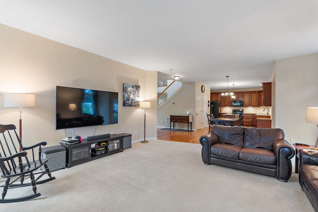 carpeted living room featuring an inviting chandelier and sink