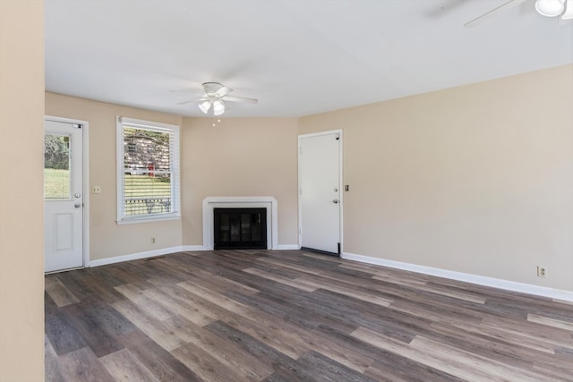 unfurnished living room featuring dark wood-type flooring and ceiling fan