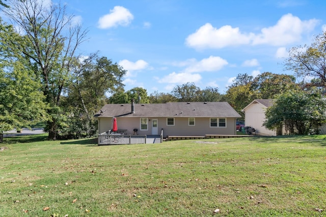 back of house featuring a deck and a lawn