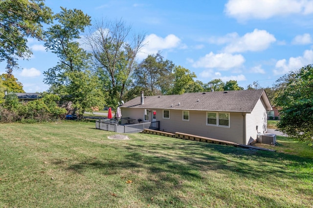 back of property with a wooden deck, cooling unit, and a yard