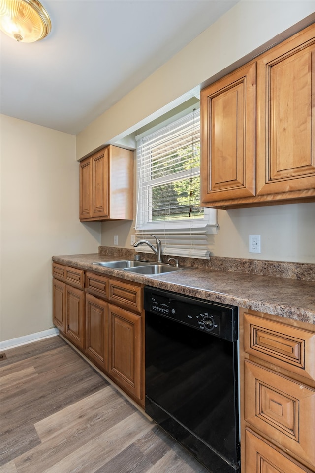 kitchen with black dishwasher, sink, and hardwood / wood-style floors