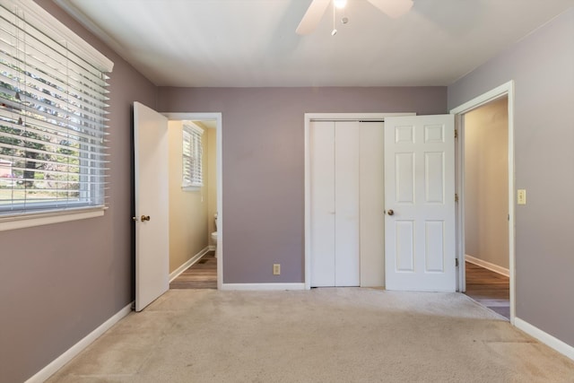 unfurnished bedroom featuring a closet, light colored carpet, and ceiling fan