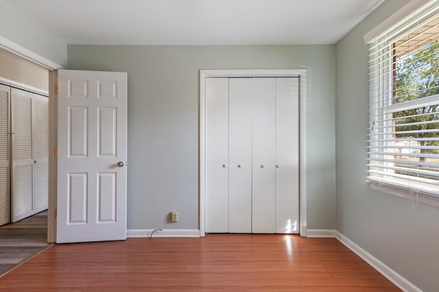 unfurnished bedroom with light hardwood / wood-style flooring and a closet