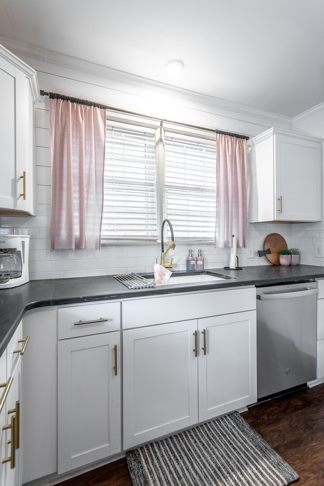 kitchen with decorative backsplash, white cabinets, dark hardwood / wood-style flooring, stainless steel dishwasher, and sink