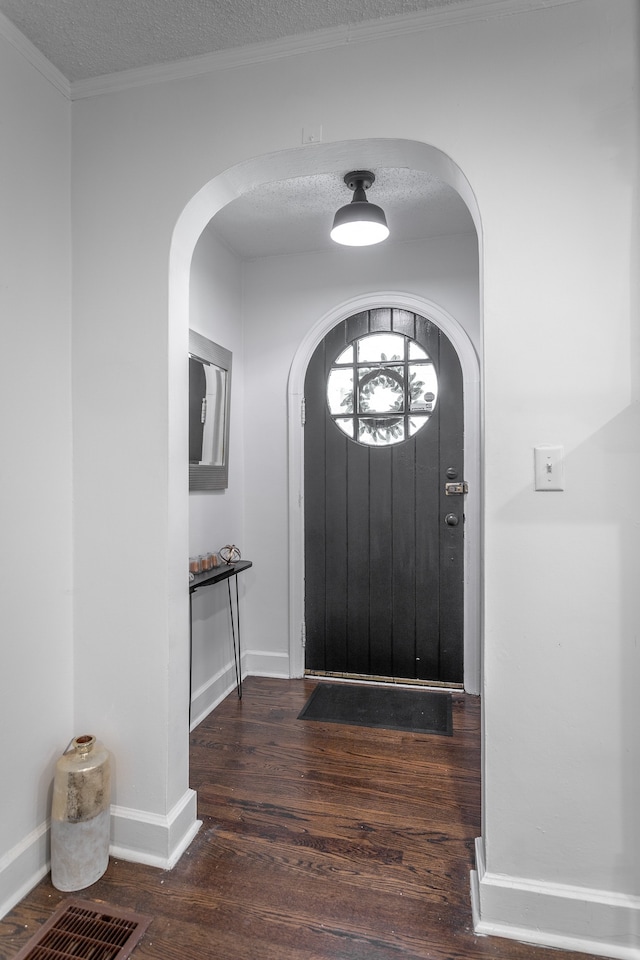 entrance foyer with ornamental molding, a textured ceiling, and dark hardwood / wood-style flooring