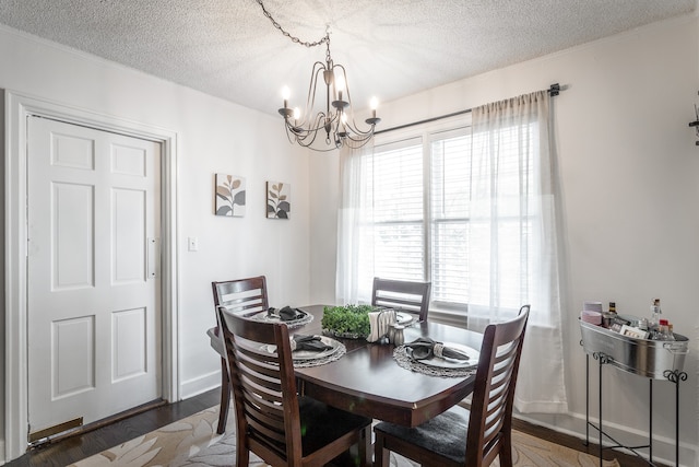 dining space featuring a textured ceiling, an inviting chandelier, and dark hardwood / wood-style floors