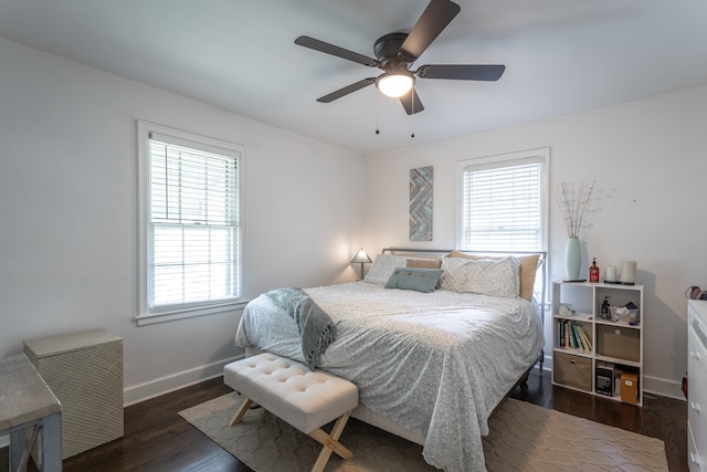 bedroom featuring dark hardwood / wood-style flooring, multiple windows, and ceiling fan