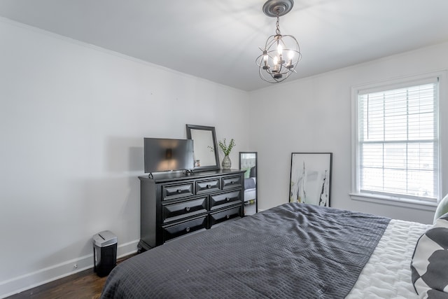 bedroom featuring crown molding, dark hardwood / wood-style floors, and a chandelier