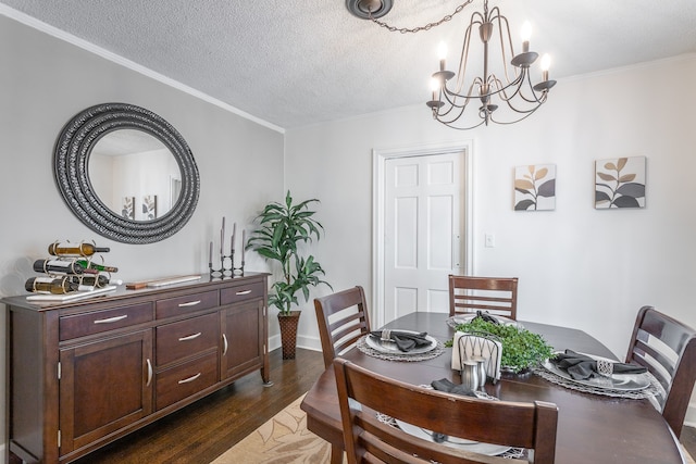 dining room featuring dark wood-type flooring, crown molding, a textured ceiling, and an inviting chandelier