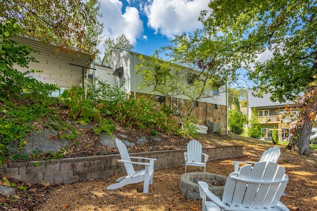 view of yard featuring a balcony and a fire pit