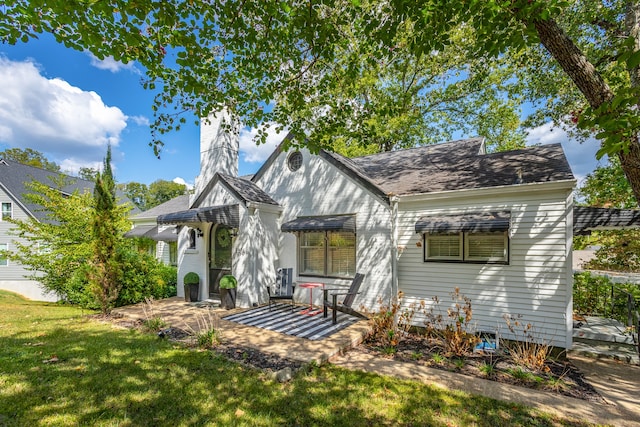 view of front of house with a patio area and a front yard