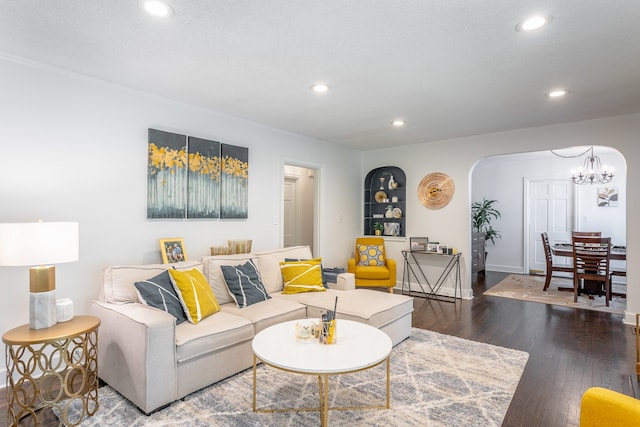 living room featuring an inviting chandelier and dark hardwood / wood-style floors