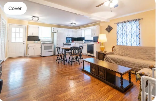 living room featuring beamed ceiling, sink, light wood-type flooring, and ceiling fan