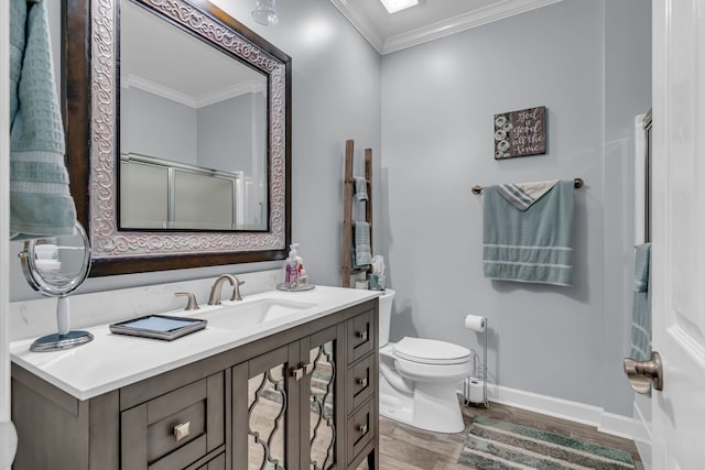 bathroom with a shower with door, toilet, crown molding, hardwood / wood-style floors, and vanity