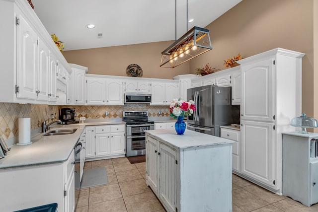 kitchen with sink, a kitchen island, white cabinetry, stainless steel appliances, and pendant lighting