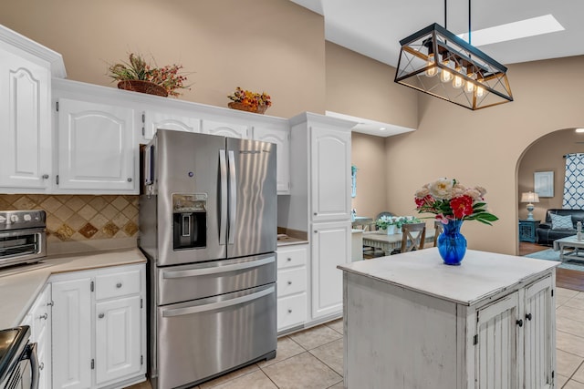 kitchen with white cabinets, hanging light fixtures, stainless steel appliances, and light tile patterned flooring