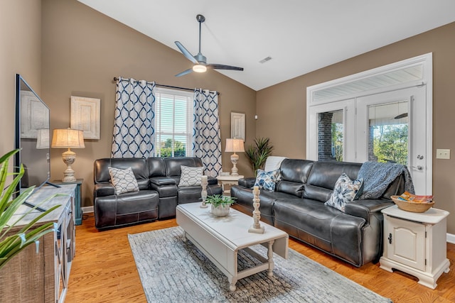 living room with light hardwood / wood-style flooring, lofted ceiling, and ceiling fan