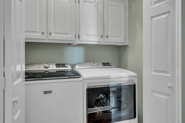 washroom featuring washer and clothes dryer and cabinets