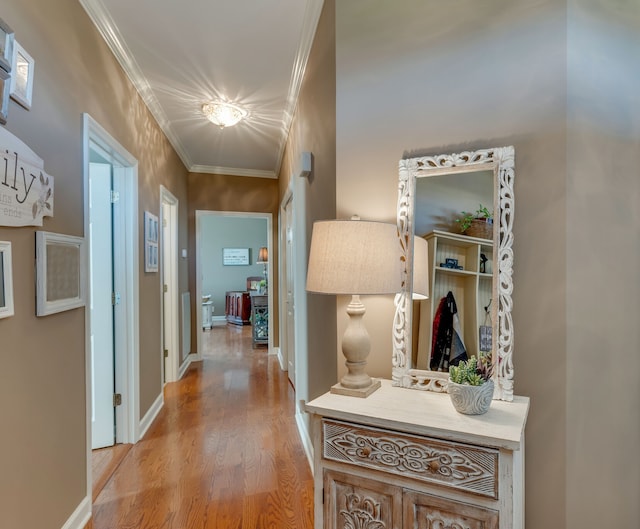 hallway with crown molding and light wood-type flooring