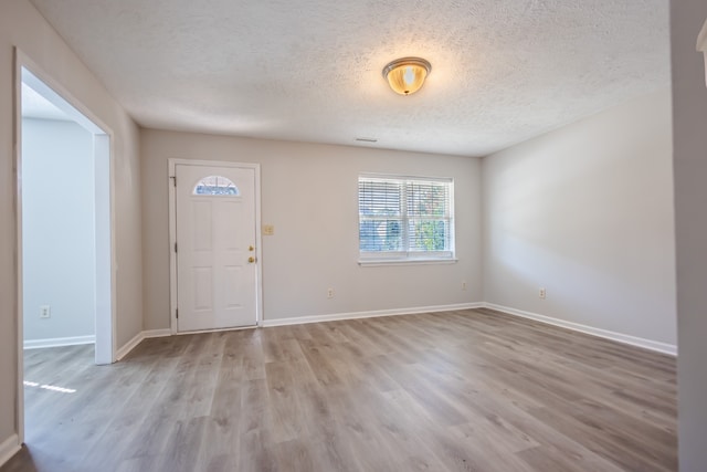 foyer with light hardwood / wood-style flooring and a textured ceiling