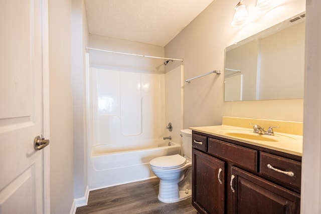 full bathroom with hardwood / wood-style floors, a textured ceiling, toilet, vanity, and bathing tub / shower combination