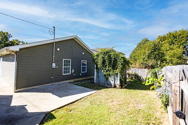 exterior space featuring a patio area, a lawn, and a storage shed