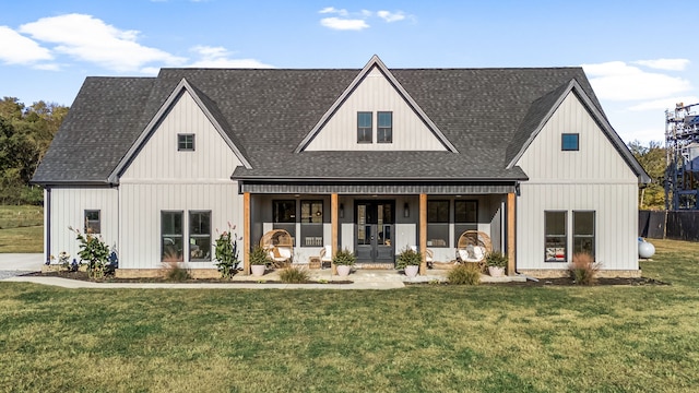 modern farmhouse style home featuring french doors, covered porch, a front yard, and a shingled roof