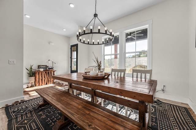 dining space featuring a chandelier, recessed lighting, baseboards, and wood finished floors