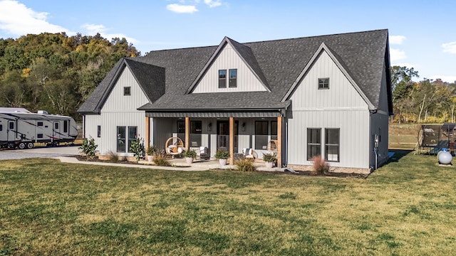 modern inspired farmhouse featuring a front lawn, a porch, and a shingled roof