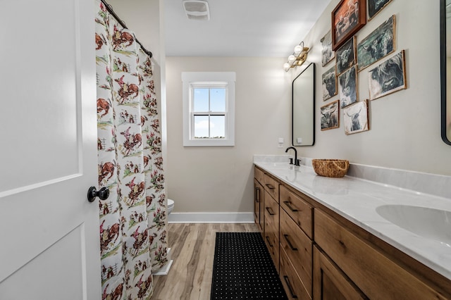 bathroom with toilet, hardwood / wood-style flooring, and vanity