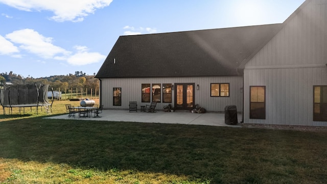 5233 Winchester Hwy, Lynchburg, TN 37352 - back of house with a lawn, roof with shingles, a patio area, and a trampoline