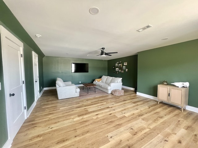 unfurnished living room featuring a ceiling fan, visible vents, light wood finished floors, and baseboards