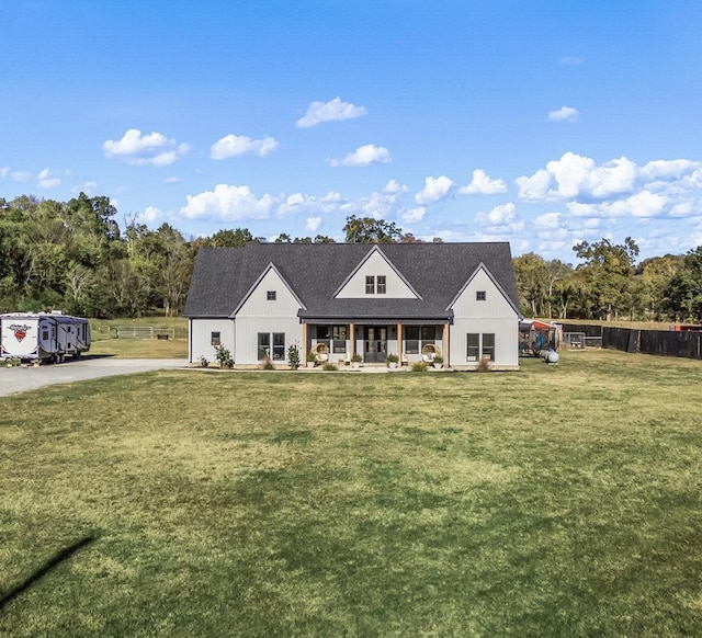 modern farmhouse with a front lawn and fence