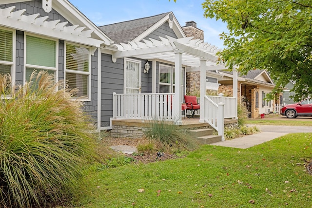 view of front of home featuring covered porch, a front lawn, and a pergola