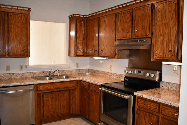 kitchen featuring sink, light stone countertops, stainless steel appliances, and light tile patterned flooring