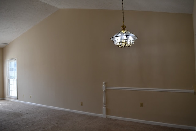 unfurnished room featuring carpet, vaulted ceiling, a textured ceiling, and a chandelier