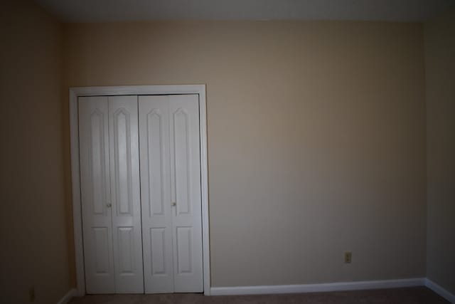 unfurnished bedroom with a closet and carpet flooring