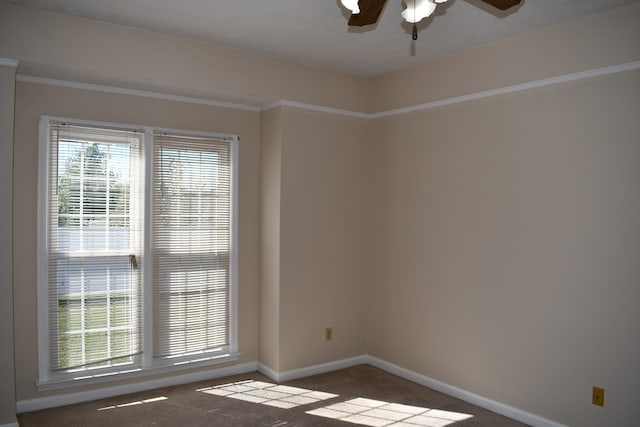 carpeted empty room featuring ceiling fan and crown molding