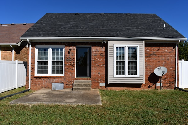 rear view of house with a patio and a lawn