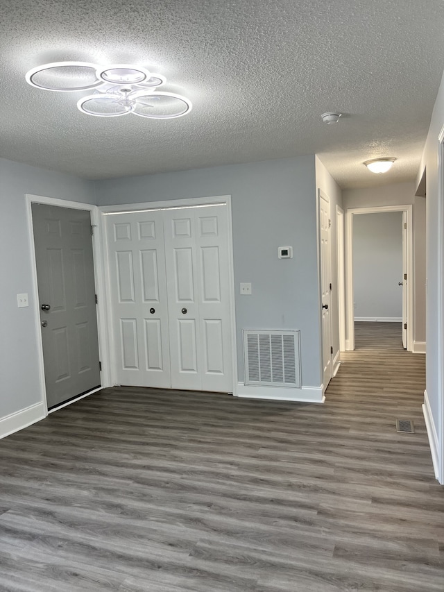 hallway featuring a textured ceiling and dark hardwood / wood-style flooring