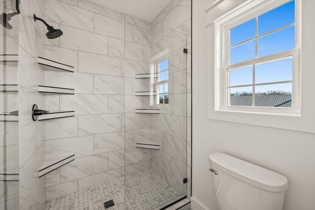 bathroom featuring toilet and a shower with shower door