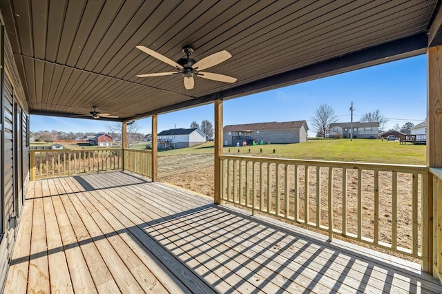 wooden terrace with ceiling fan and a lawn