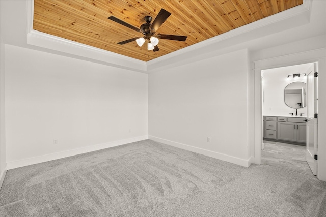 spare room featuring a tray ceiling, crown molding, light colored carpet, and wooden ceiling