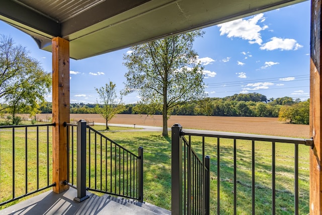 wooden deck featuring a rural view and a lawn